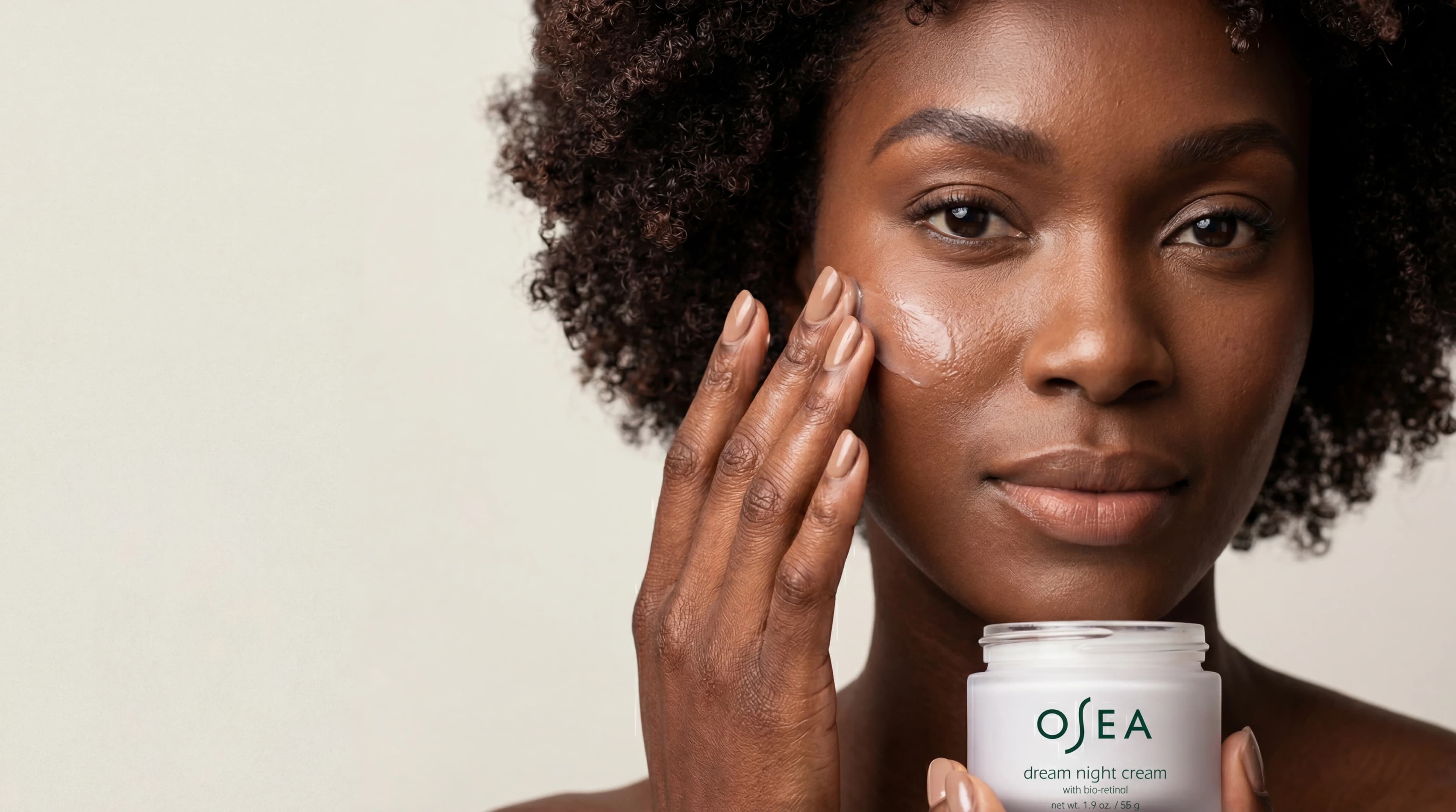Woman applying OSEA skincare cream with jar visible — AI beauty product photography for ecommerce brands