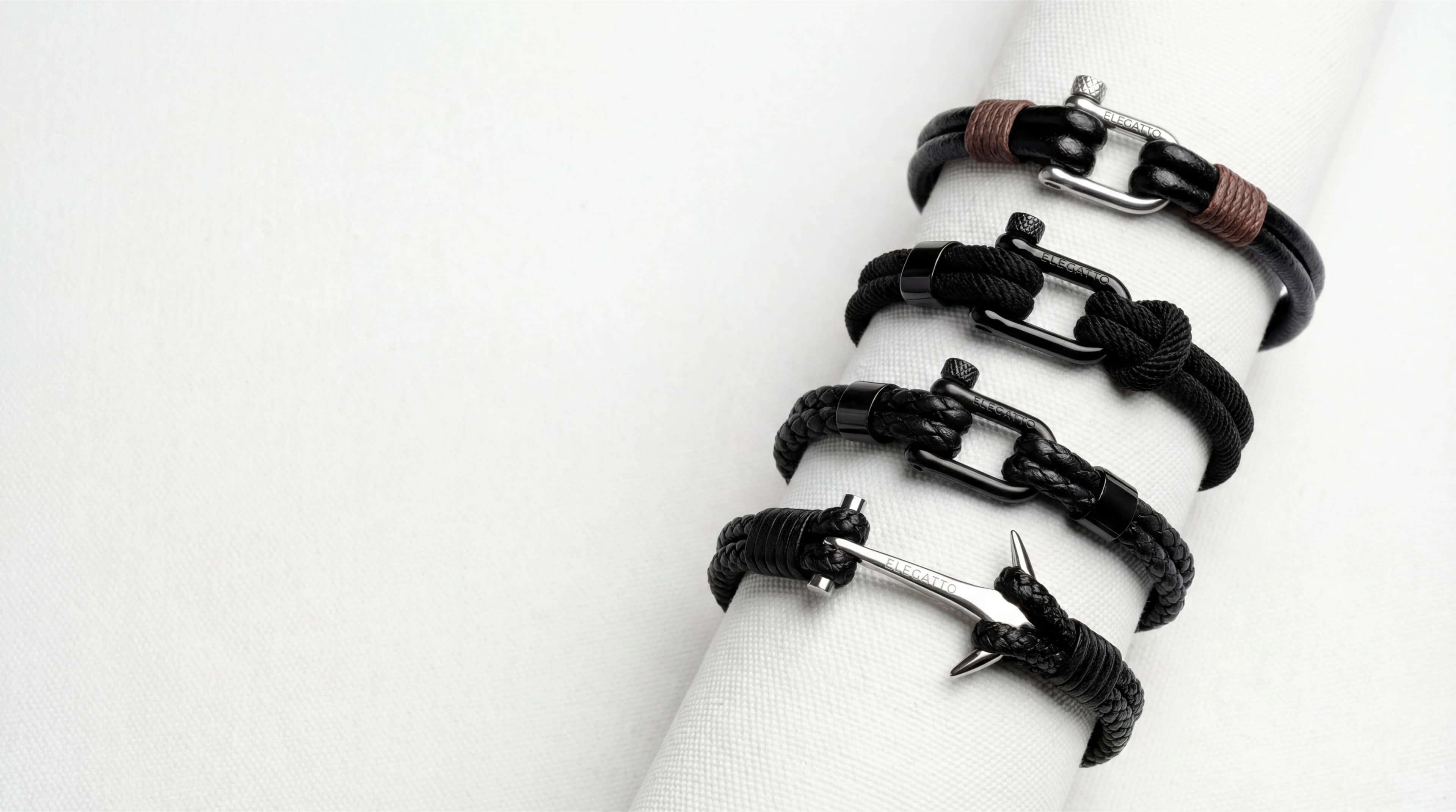 Black leather and cord bracelets on white display — AI accessories product photography for ecommerce
